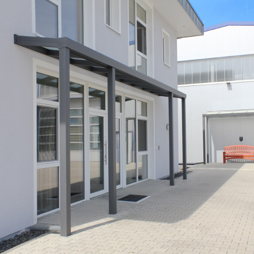 Moderne Eingangsüberdachung aus Glas und Aluminium für Gewerbegebäude – Wetterschutz & stilvolle Architektur