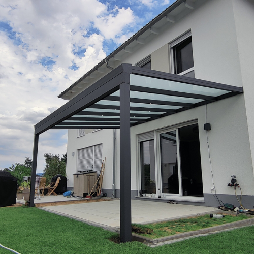 Terrassenüberdachung mit hochwertigen Möbeln und direktem Blick in den Garten